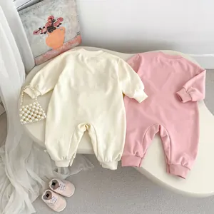 Détail de bodies bébé à manches longues crème et rose avec poignets côtelés et coton doux