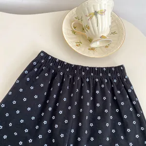 Detail of floral black skirt fabric with elastic waistband and small white flowers