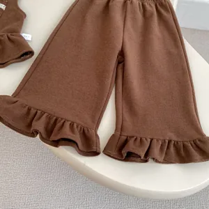 Detailed view of dark brown toddler pants with ruffled hems and elastic waist in soft knit