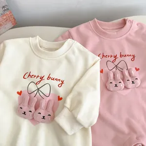 Détail des lapins 3D et de la broderie Cherry Bunny sur les barboteuses bébé