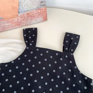 Detailed close-up of a floral girl's camisole top with blue flowers on black fabric