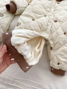 Detail view of thickened fleece lining and diamond-quilted fabric for infant jumpsuit