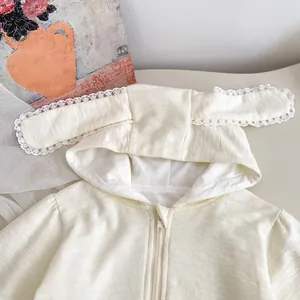 Détail du sweat à capuche bébé en maille gaufre avec oreilles de lapin et dentelle