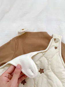 Detail showing the thick fleece lining and star embroidery on infant quilted overalls