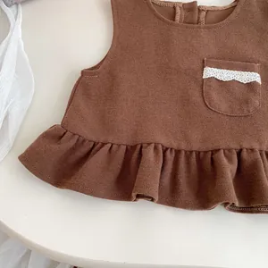 Three-piece girls' autumn outfit featuring a brown waffle knit vest with ruffle hem