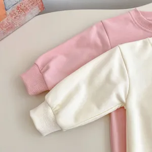 Détail des poignets côtelés et tissu en coton doux sur bodies rose et beige