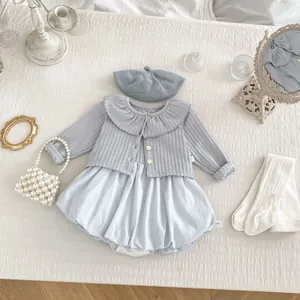 Detail von hellblauer Strickjacke mit Rüschenkragen und Baby-Blumen-Blasenfkleid-Set
