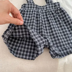 Close-up of black and white checkered suspender shorts for toddlers with soft cotton texture