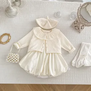 Detailansicht von Baby-Mädchen-Strickjacke und Romper-Set mit feiner cremefarbener Textur