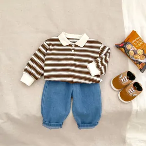 Flat lay of boys' striped long-sleeve polo shirt and rolled cuff denim pants set