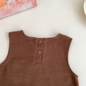 Close-up of caramel knit vest showing ribbed cotton texture and back button details
