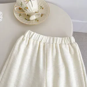 Détail du pantalon en maille crème avec taille élastique confortable et texture côtelée