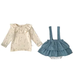 Infant fall set featuring beige bow print top and blue corduroy suspender skirt outfit