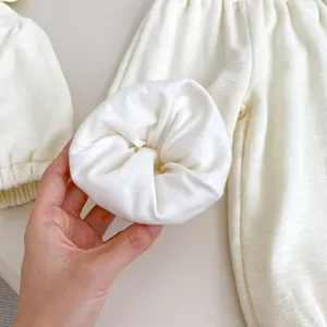 Détail du tissu gaufré en coton doux sur un pantalon pour bébé avec texture d'ourlet plié