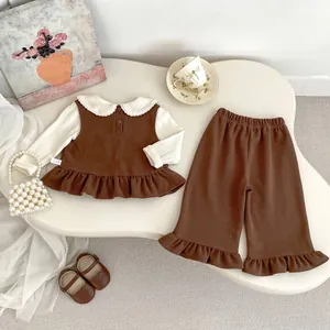 Detail of girl's autumn knit set featuring brown ruffle hem top and matching flared pants