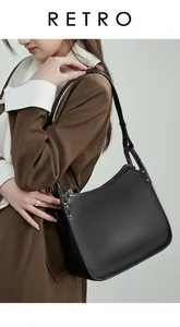 Detail of black lychee grain leather shoulder bag featuring silver metal rivets and a zipper
