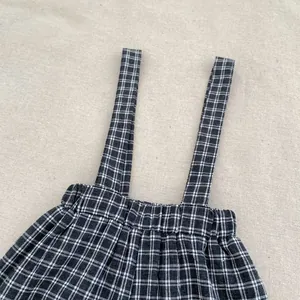 Close-up of black and white plaid toddler suspender pants with elastic waistband texture