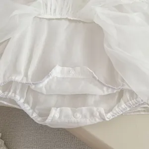 Detailed macro view of the snap buttons and soft mesh layers on this baby princess bodysuit
