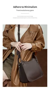 Detail of dark brown lychee grain leather handbag with silver rivets on brown trench coat