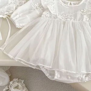Detail of baby girl white lace bodysuit dress with floral embroidery and soft mesh skirt
