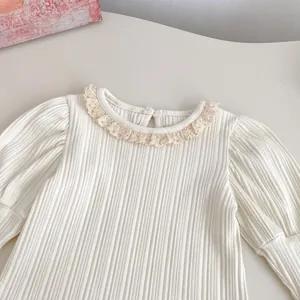 Detail van geribde gebreide top met kanten kraag en retro lantaarnmouwen ontwerp