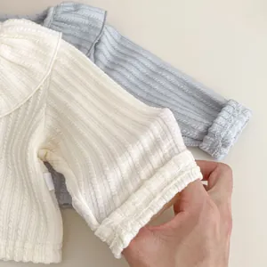 Detailaufnahme des Baby-Strickoberteils mit Rippmuster und Volantkragen in Blau und Weiß