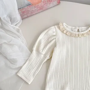 Detail van beige gebreide meisjestop met witte kanten kraag en retro pofmouwen