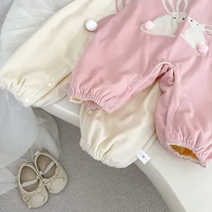 Détail de barboteuses pour bébé avec broderie lapin et pompons moelleux décoratifs