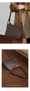 Detail of dark brown lychee grain leather tote bag with metal rivets and shoulder strap