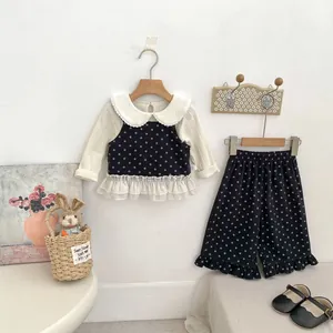 Close-up of black and white polka dot girls set with lace collar shirt and ruffled pants