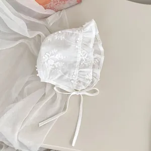 Close-up of baby lace princess bonnet with floral embroidery and ruffle edges