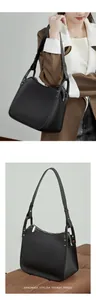 Detail of black pebbled leather handbag with silver studs and trapezoidal silhouette
