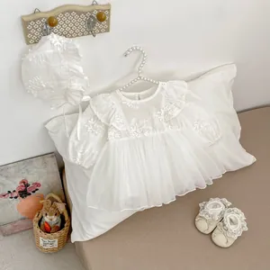 Detail of white lace baby princess dress with embroidered tulle bonnet and shoes