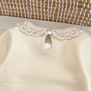 Détail du haut côtelé bébé avec col en dentelle crochetée et fermeture boutonnée au dos