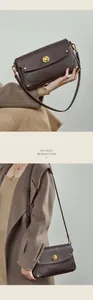 Détail du sac besace en cuir marron foncé avec clous dorés et fermoir tournant
