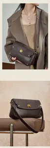 Détail du sac à bandoulière en cuir marron foncé avec fermoir rotatif en métal doré