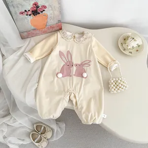 Détail d'un barboteuse bébé avec col en dentelle, broderie lapin et queue en peluche
