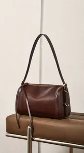 Détail du sac Boston en cuir véritable avec fermeture éclair dorée sur un banc en cuir