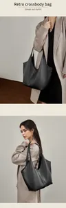 Detail einer großen schwarzen Ledertasche mit Narbenstruktur und retro-minimalistischem Design