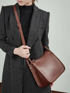Brown litchi grain leather crossbody bag with adjustable strap and top handle