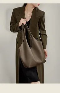 Detail einer dunkelbraunen Leder-Tote-Bag an der Schulter eines Models im Blazer