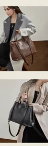 Detalle de bolsos tote de cuero en marrón y negro con correas y elegantes herrajes dorados