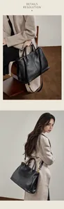 Detalle de bolso tote de cuero negro con textura de grano y herrajes metálicos dorados