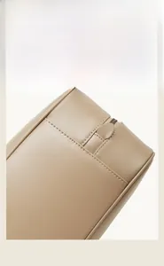 Detail shot of precision stitching and zipper craftsmanship on a beige leather bowling bag