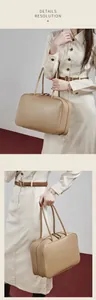 Detail view of large beige leather bowling bag with twin handles and zip closure