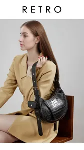 Detail of black hobo bag showing crocodile texture and detachable mini ear pouch