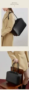 Detail view of large leather Boston bag with double handles and gold zipper hardware