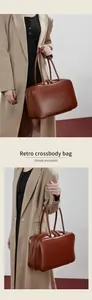 Close-up of brown vintage leather bowling bag with gold hardware and double zippers