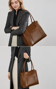 Bruine leren shopper gedragen door model bij grijze jas voor een zakelijke look