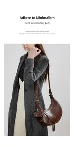 Detail of crocodile pattern leather half-moon bag with adjustable shoulder strap and mini pouch